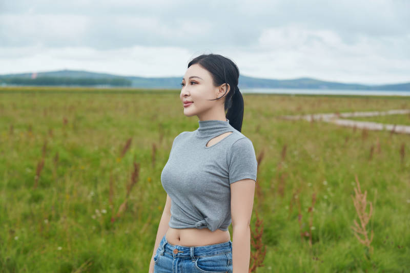 盛夏在草原花海拍照游玩的美女图片