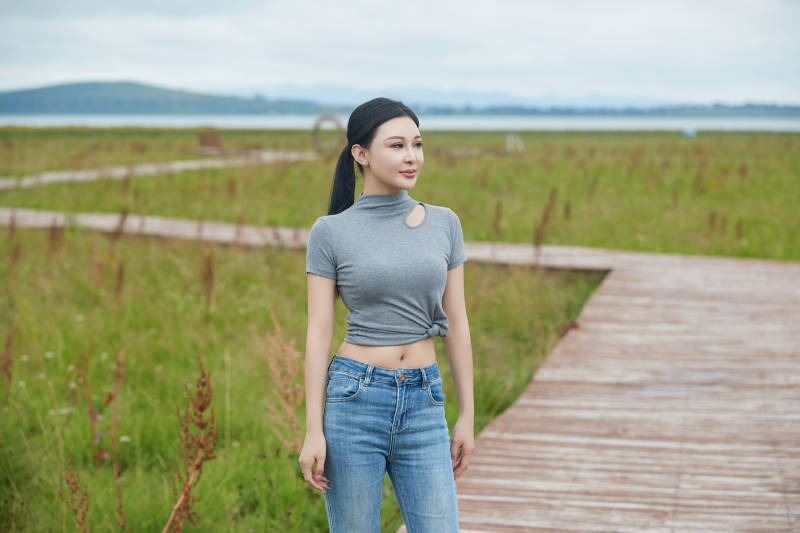 盛夏在草原花海拍照游玩的美女图片