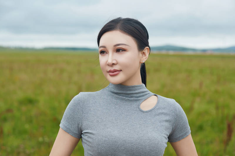 盛夏在草原花海拍照游玩的美女图片