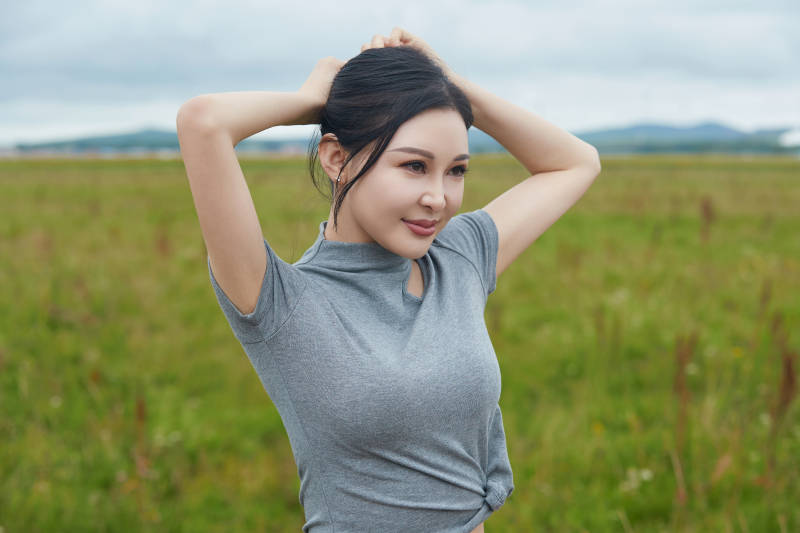 盛夏在草原花海拍照游玩的美女图片