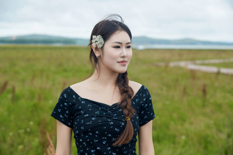 盛夏在草原花海拍照游玩的美女图片