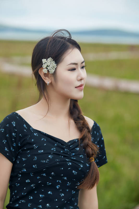 盛夏在草原花海拍照游玩的美女图片