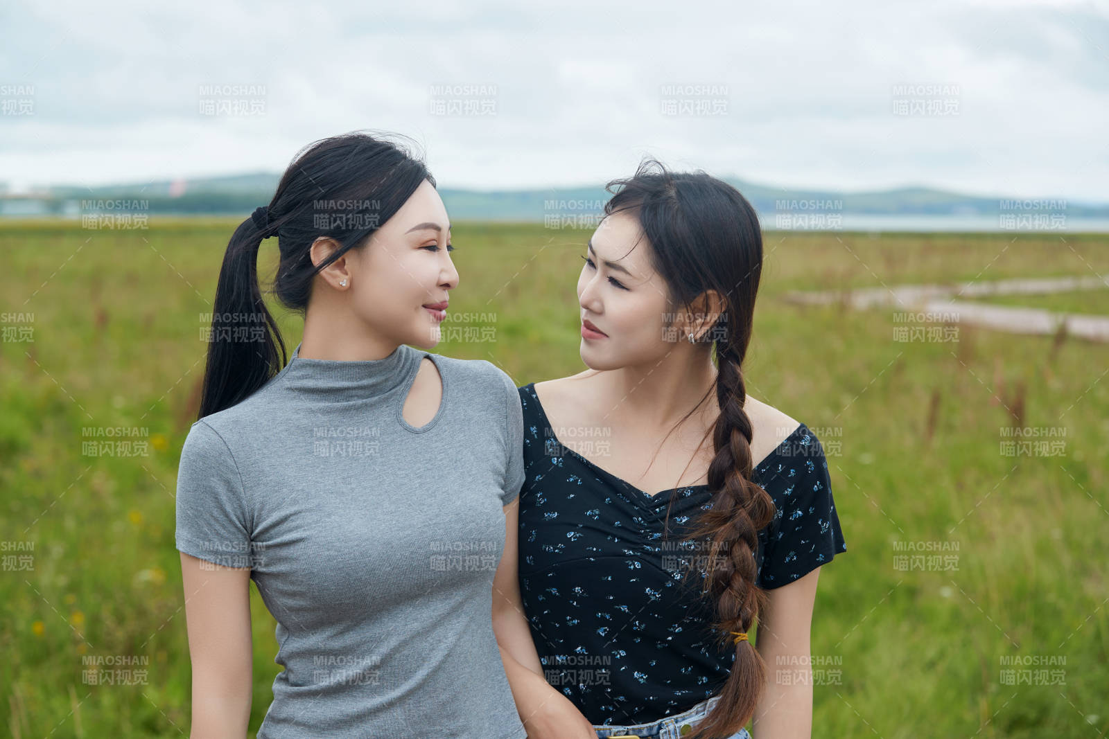 在草原花海观鸟台拍照游玩的美女闺蜜图片