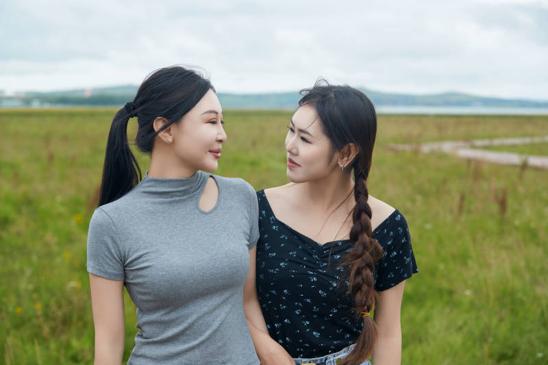 在草原花海观鸟台拍照游玩的美女闺蜜图片