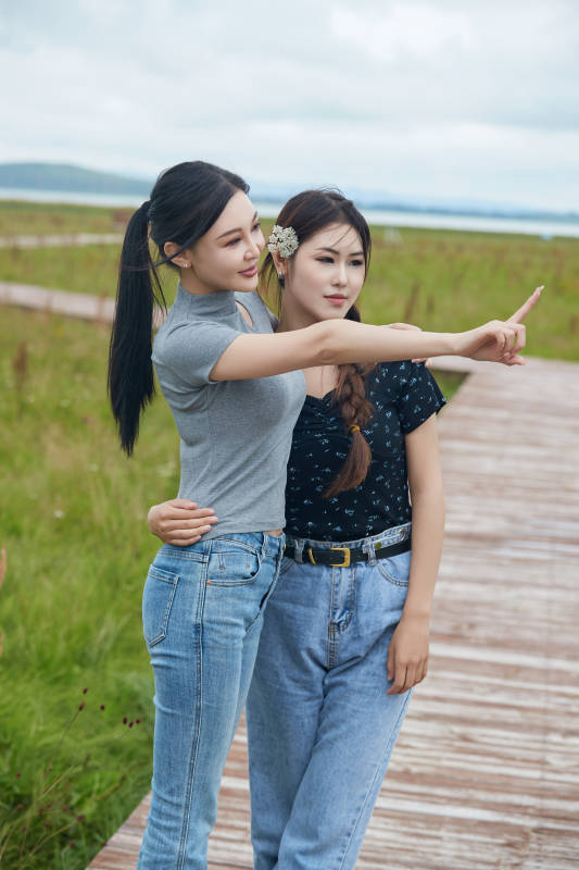 在草原花海观鸟台拍照游玩的美女闺蜜图片