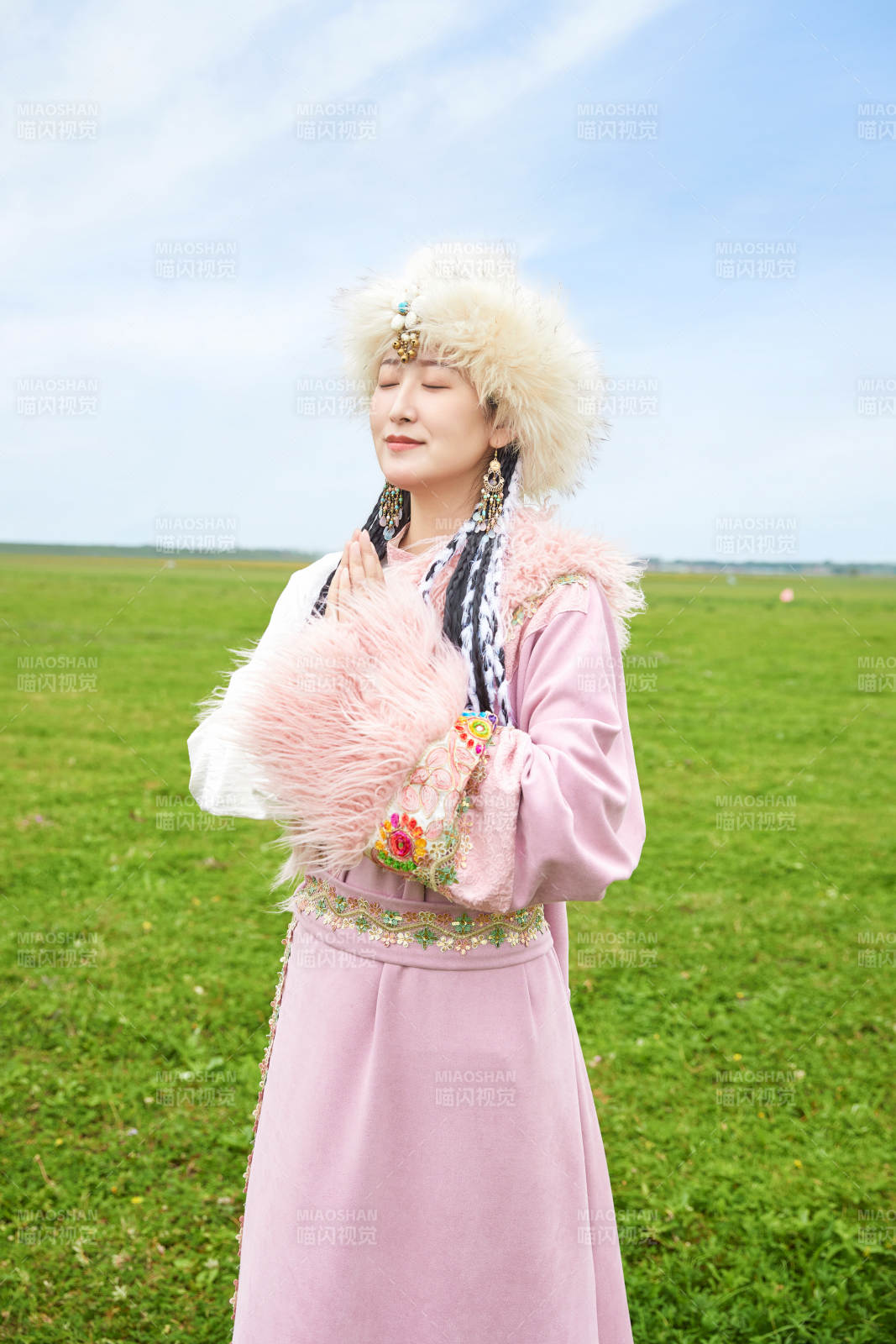 身穿藏族服饰在草原景区拍照的美女图片