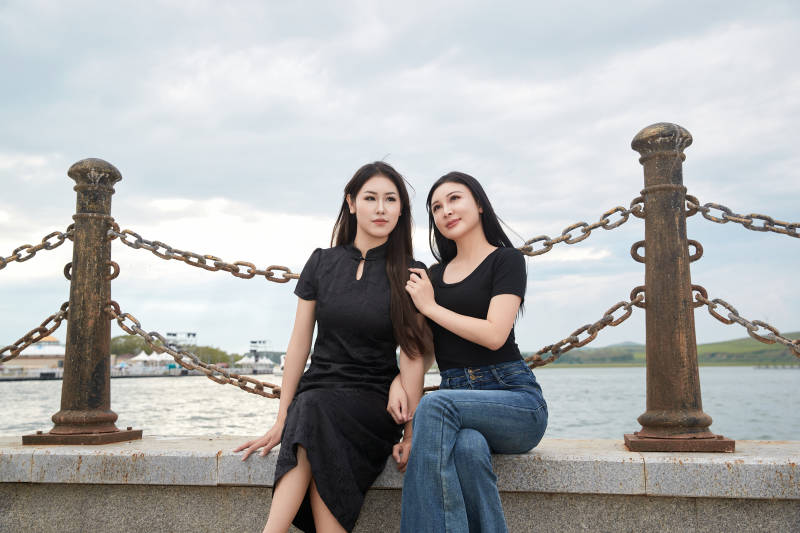 在旅游区湖边打卡点拍照的美女闺蜜图片