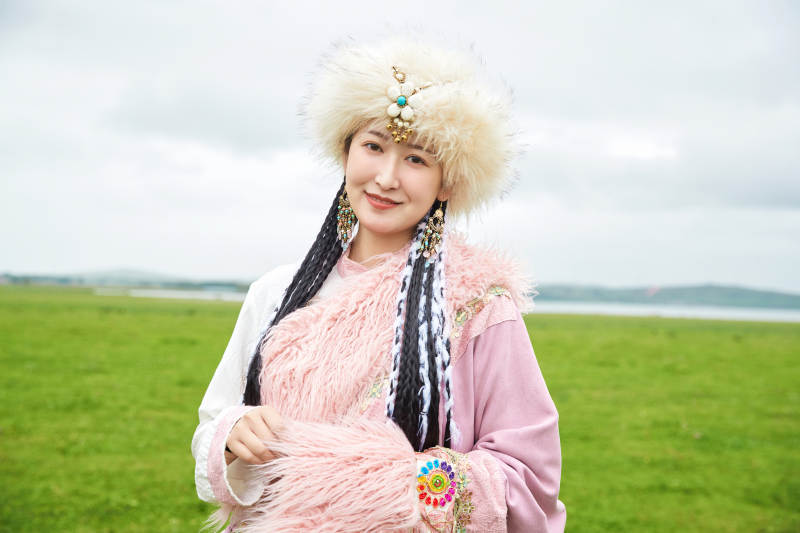 身穿藏族服饰在草原景区拍照的美女图片