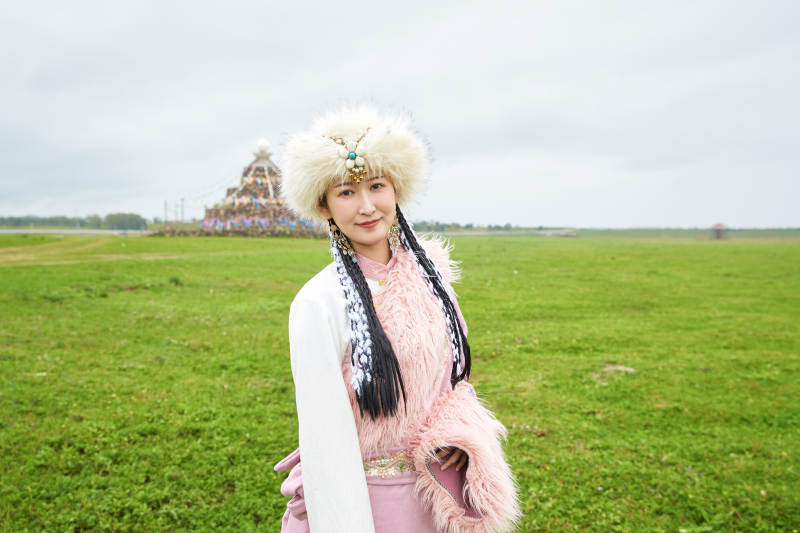 身穿藏族服饰在草原景区拍照的美女图片