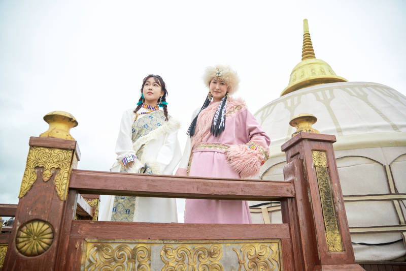 身穿藏族服饰在草原拍照游玩的闺蜜图片