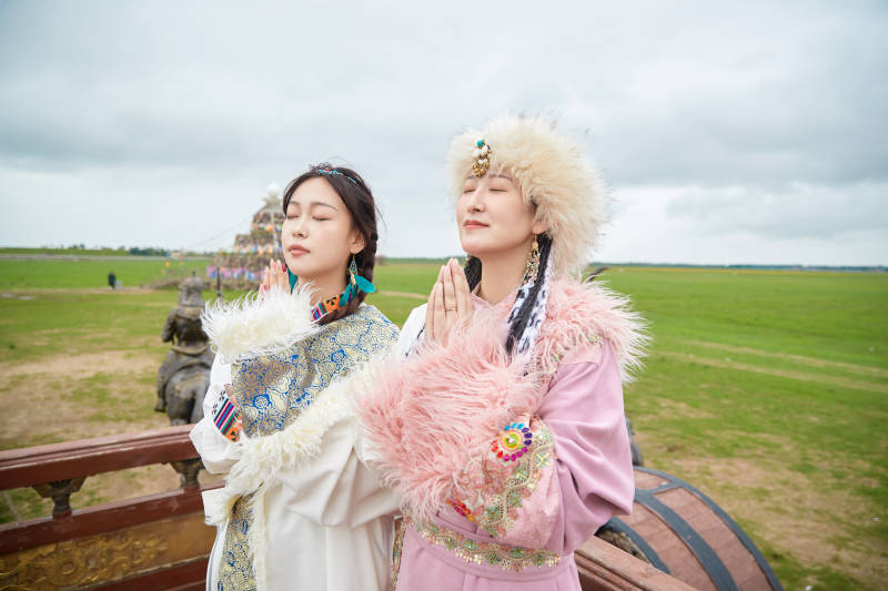 身穿藏族服饰在草原拍照游玩的闺蜜图片