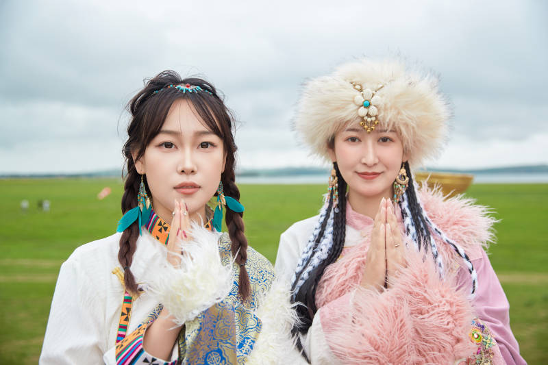 身穿藏族服饰在草原拍照游玩的闺蜜图片