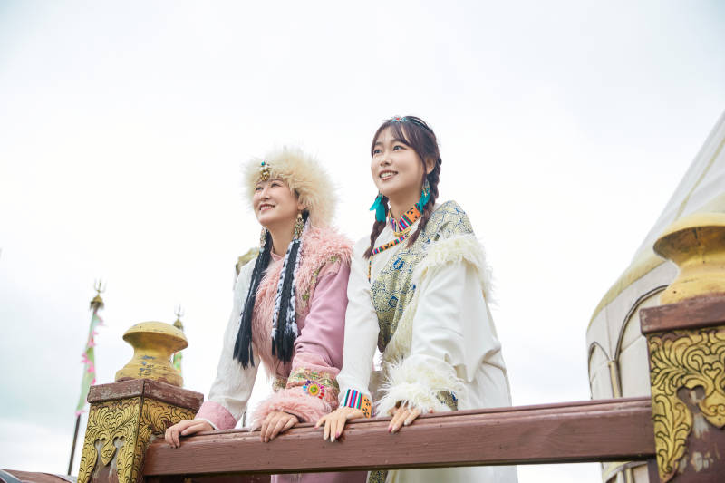 身穿藏族服饰在草原拍照游玩的闺蜜图片