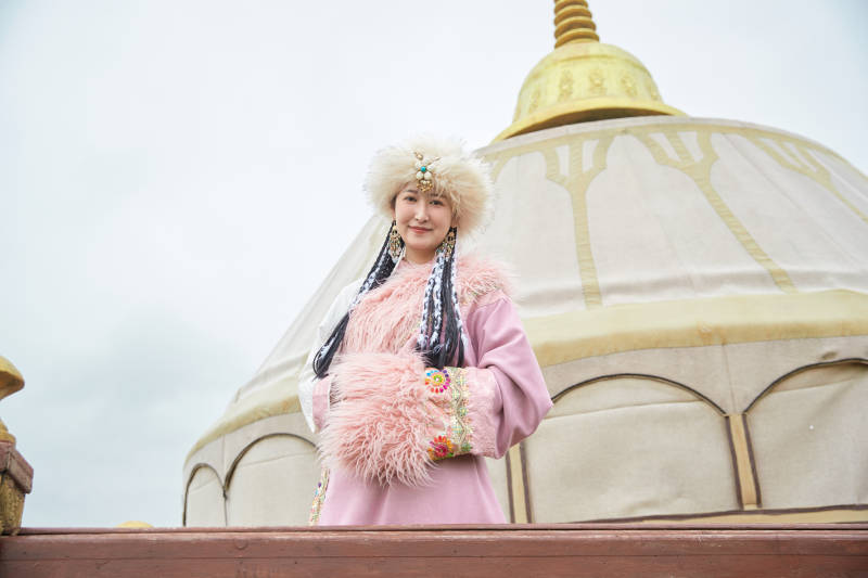 身穿藏族服饰在草原景区拍照的美女图片