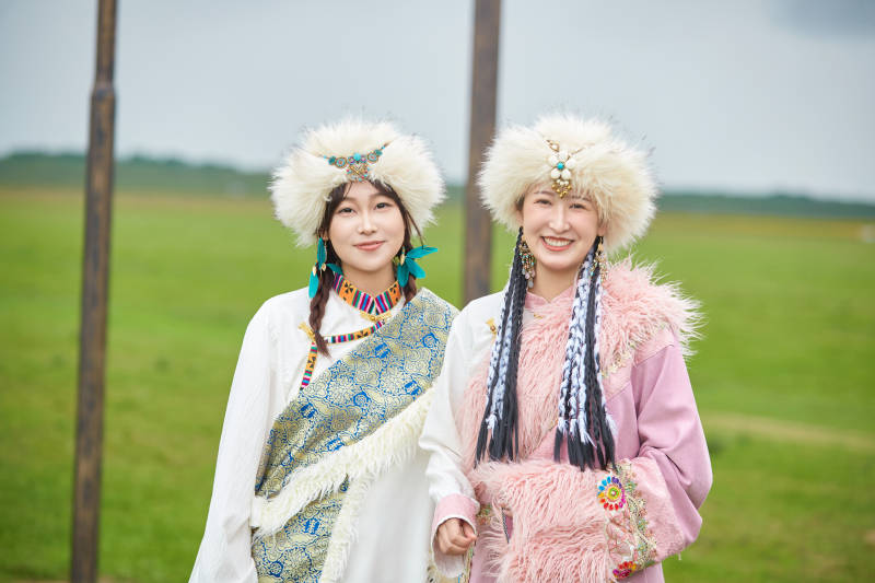 身穿藏族服饰在草原拍照游玩的闺蜜图片