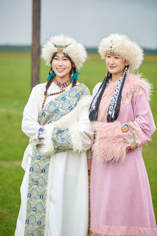 身穿藏族服饰在草原拍照游玩的闺蜜图片