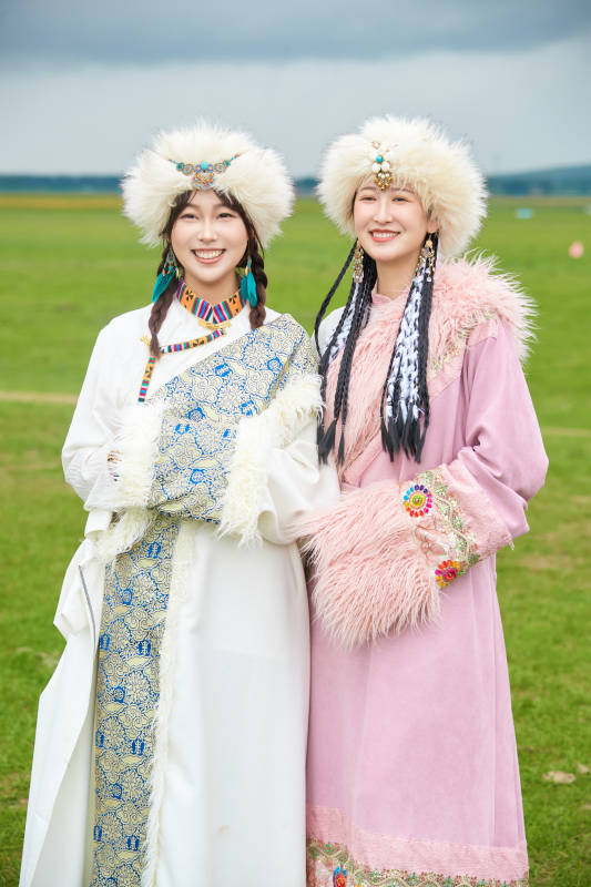 身穿藏族服饰在草原拍照游玩的闺蜜图片