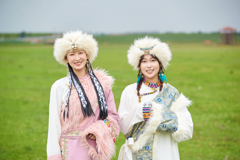 身穿藏族服饰在草原拍照游玩的闺蜜图片