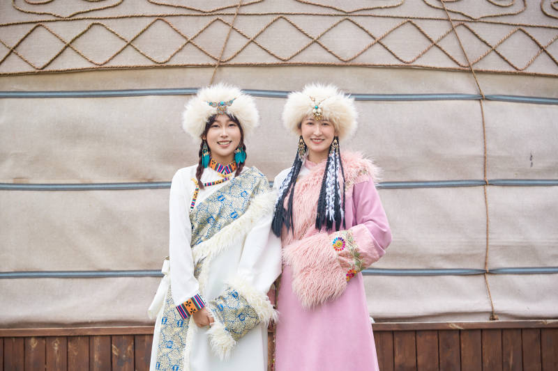 身穿藏族服饰在草原拍照游玩的闺蜜图片