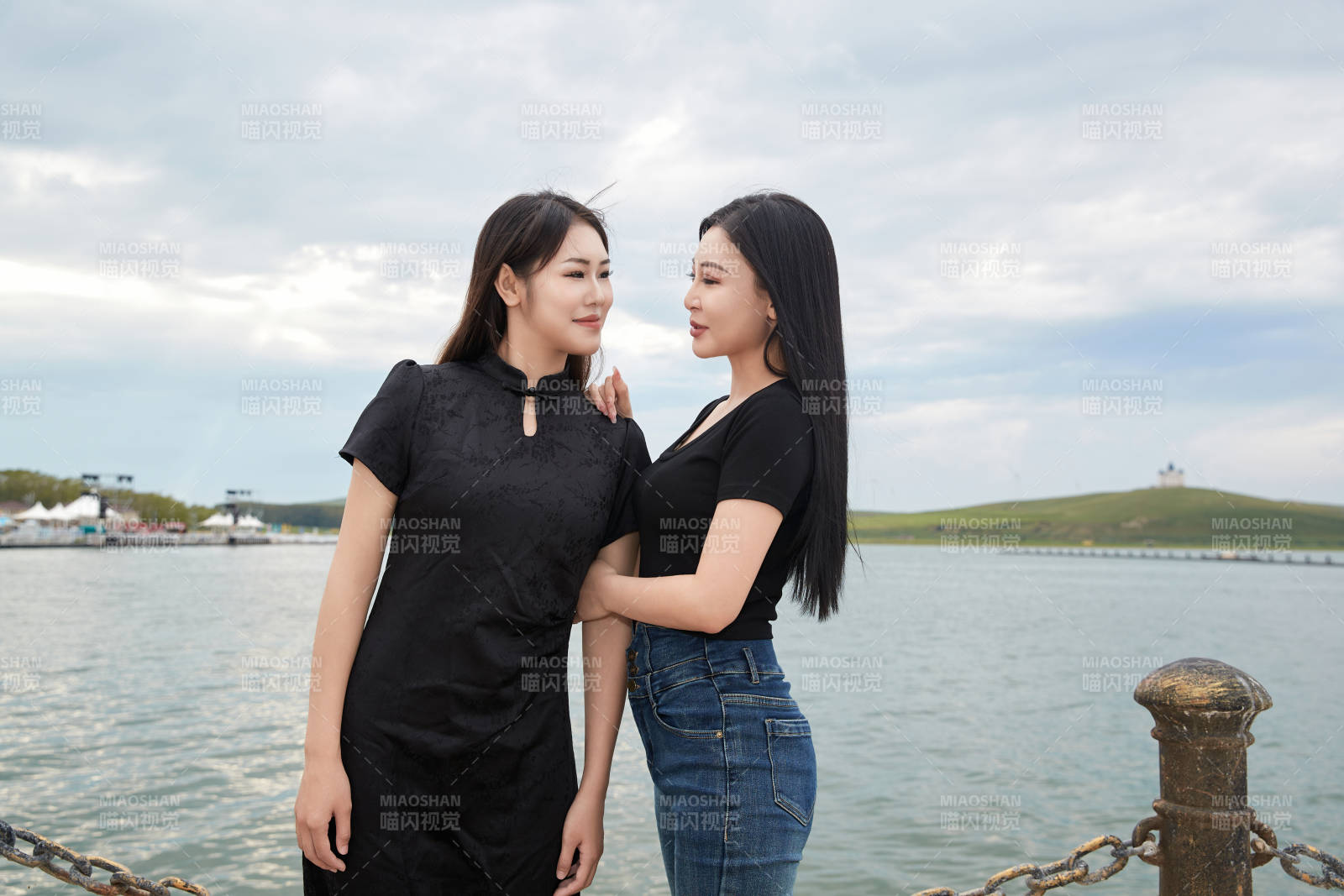 在旅游区湖边打卡点拍照的美女闺蜜图片