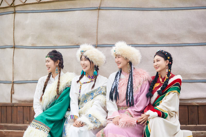 穿藏族服饰在草原拍照游玩的姑娘们图片