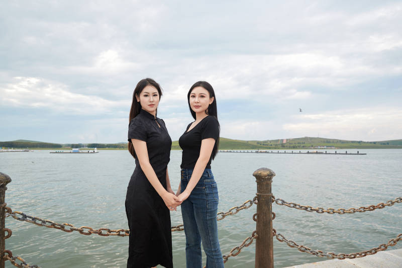 在旅游区湖边打卡点拍照的美女闺蜜图片