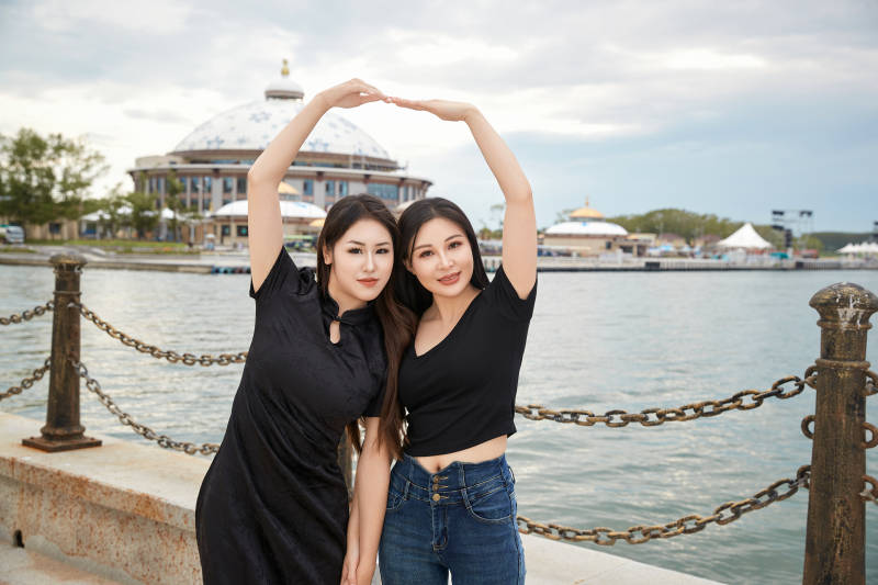 在旅游区湖边打卡点拍照的美女闺蜜图片