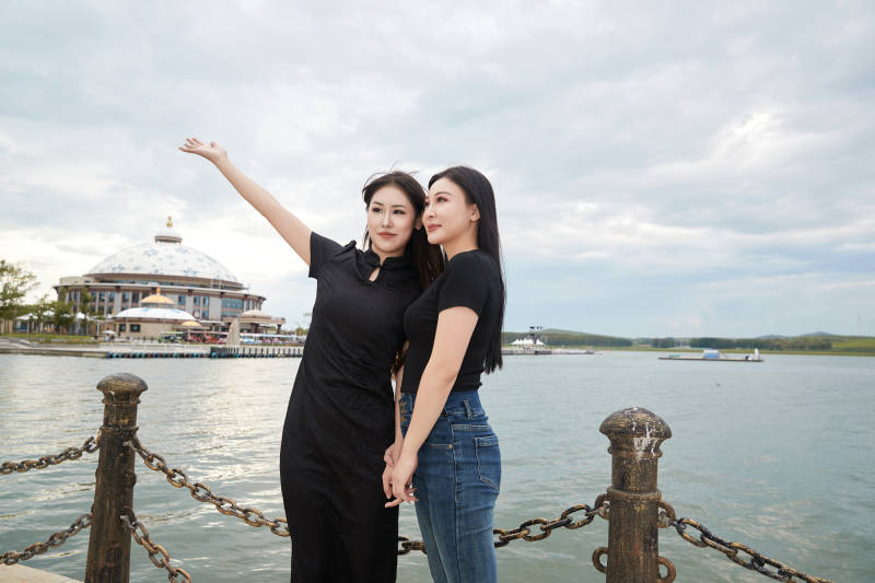 在旅游区湖边打卡点拍照的美女闺蜜图片