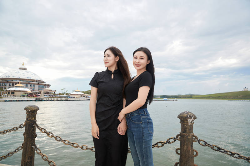 在旅游区湖边打卡点拍照的美女闺蜜图片