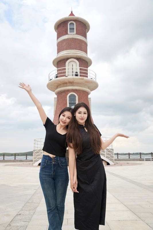 在旅游区湖边打卡点拍照的美女闺蜜图片