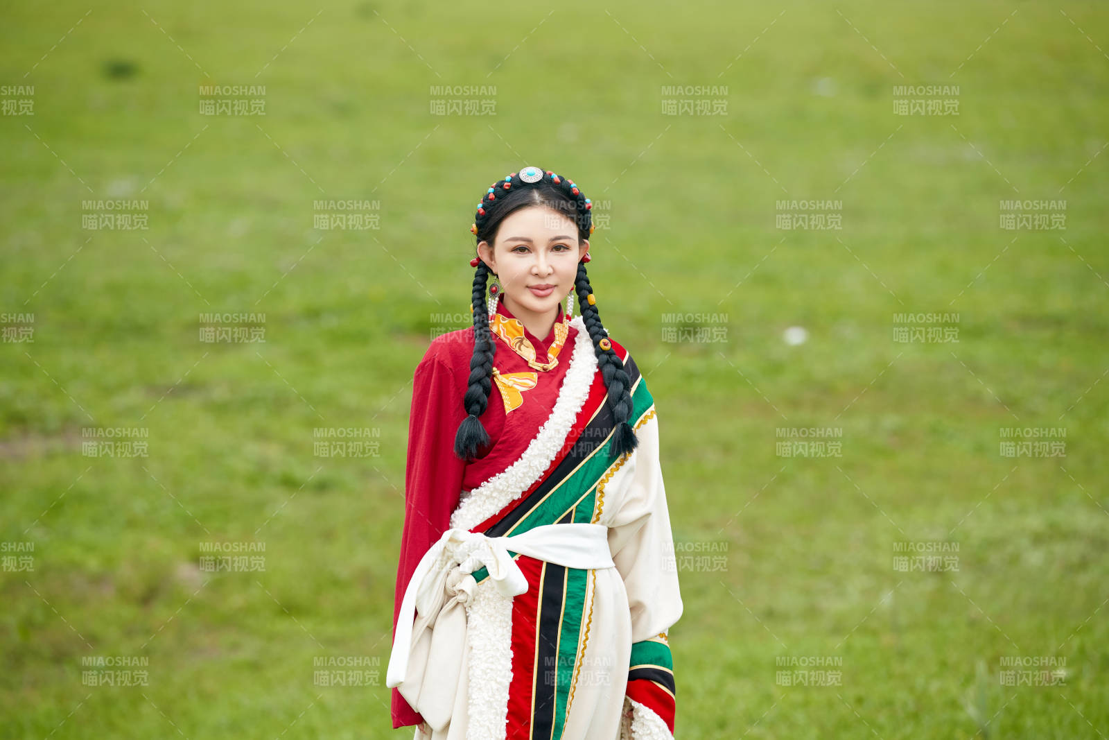 身穿藏族服饰在草原景区拍照的美女图片