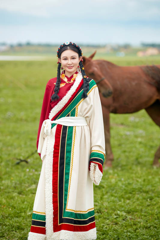 身穿藏族服饰和马匹拍照的美女图片
