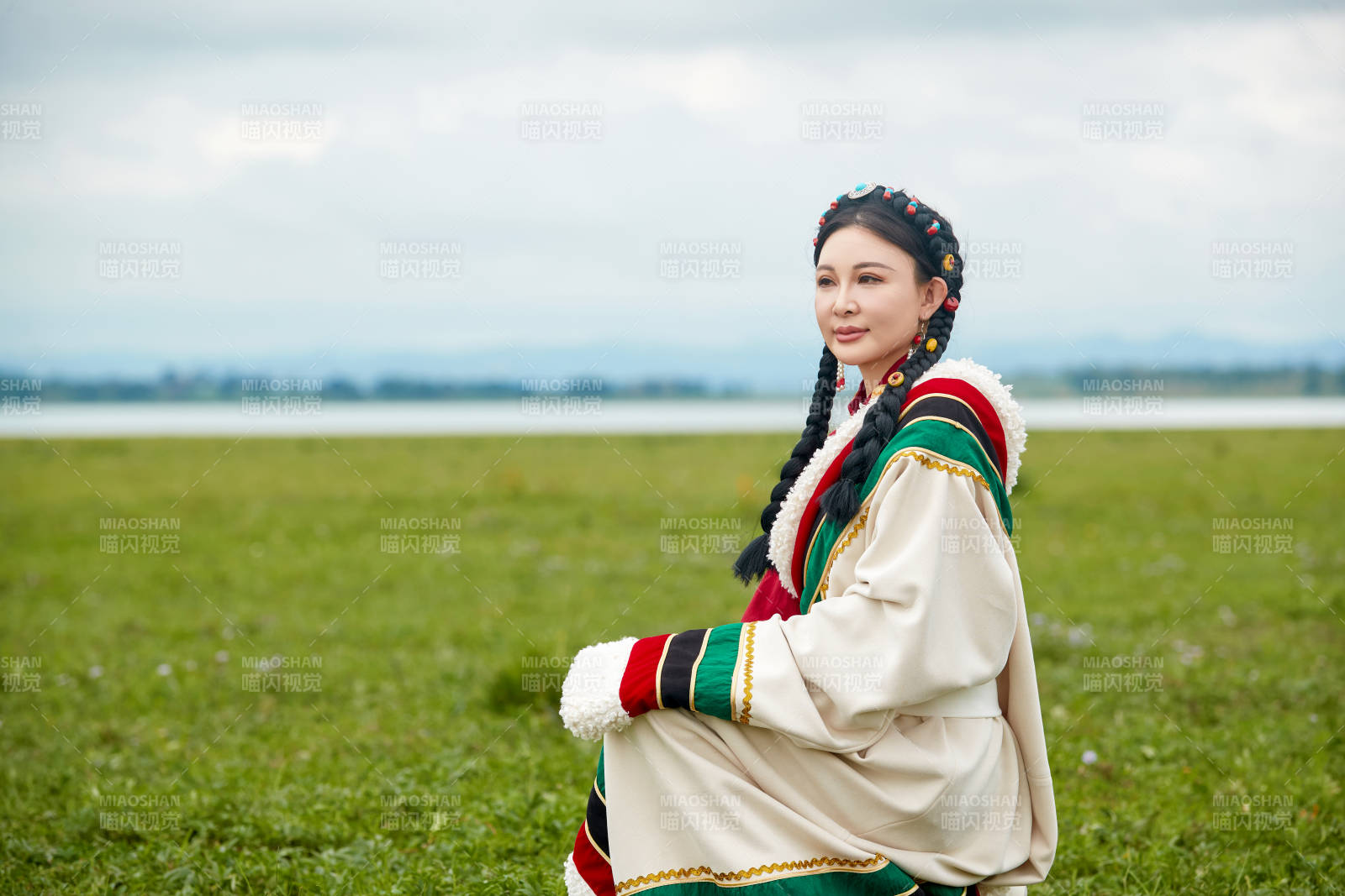 身穿红色藏族服饰在草原景区拍照的美女图片