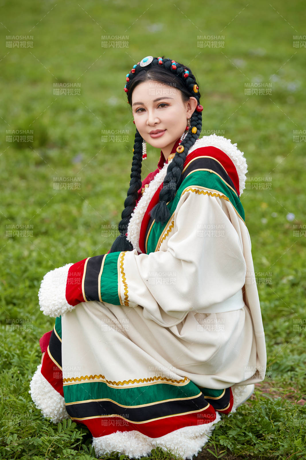 身穿红色藏族服饰在草原景区拍照的美女图片