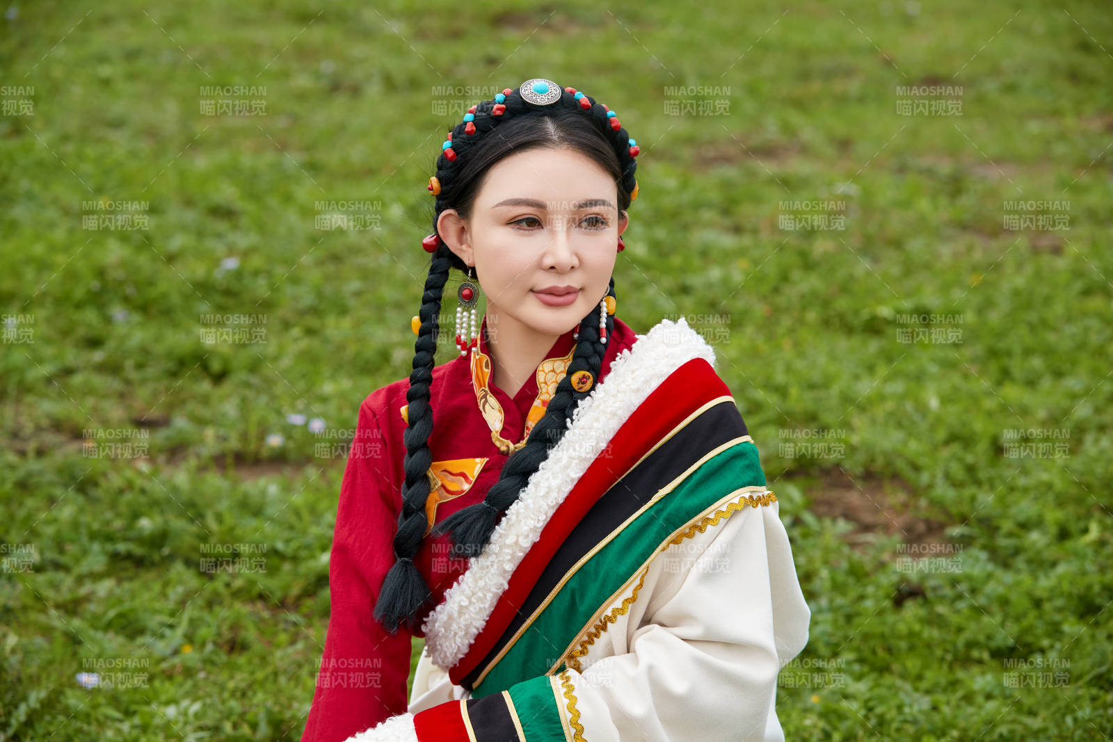 身穿红色藏族服饰在草原景区拍照的美女图片