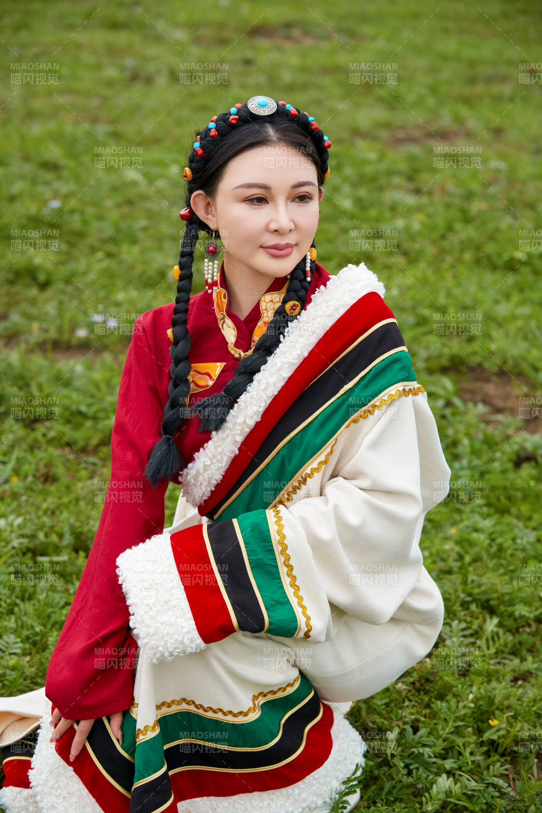 身穿红色藏族服饰在草原景区拍照的美女图片
