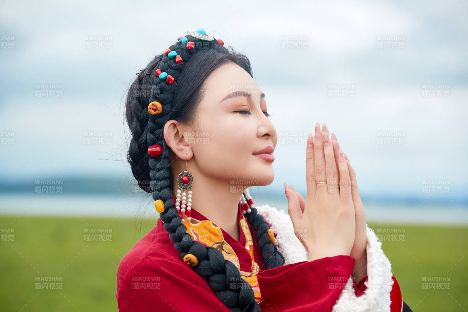 身穿红色藏族服饰在草原景区拍照的美女图片