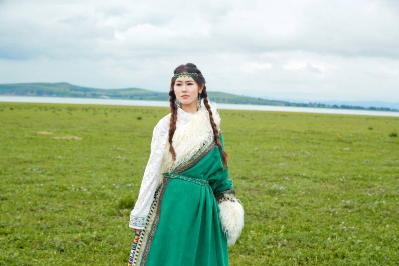 身穿绿色藏族服饰在草原跳舞的美女图片