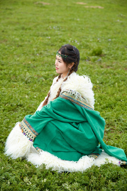 身穿绿色藏族服饰在草原跳舞的美女图片