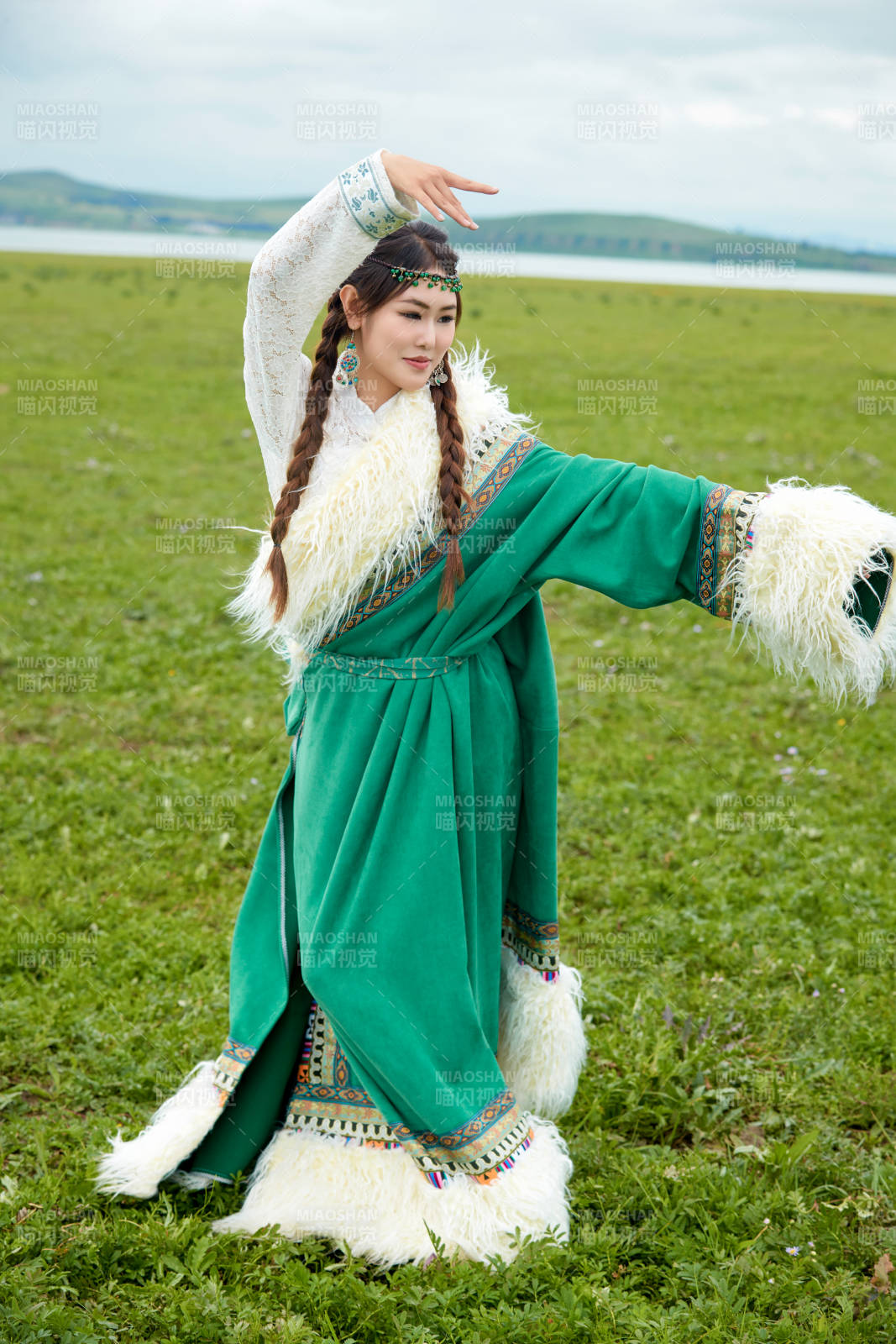 身穿绿色藏族服饰在草原跳舞的美女图片