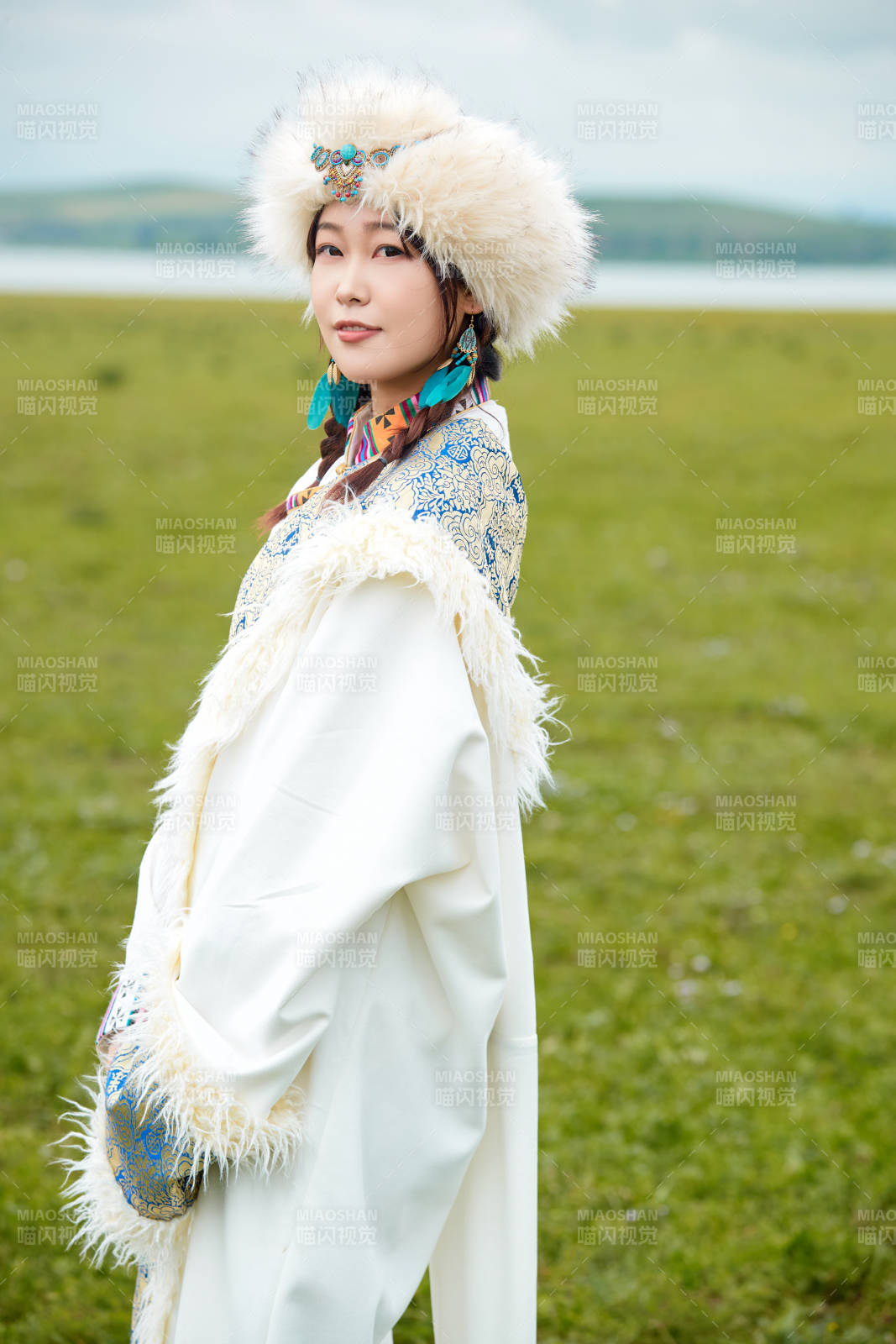 穿白色藏族服饰在草原拍照的少女图片