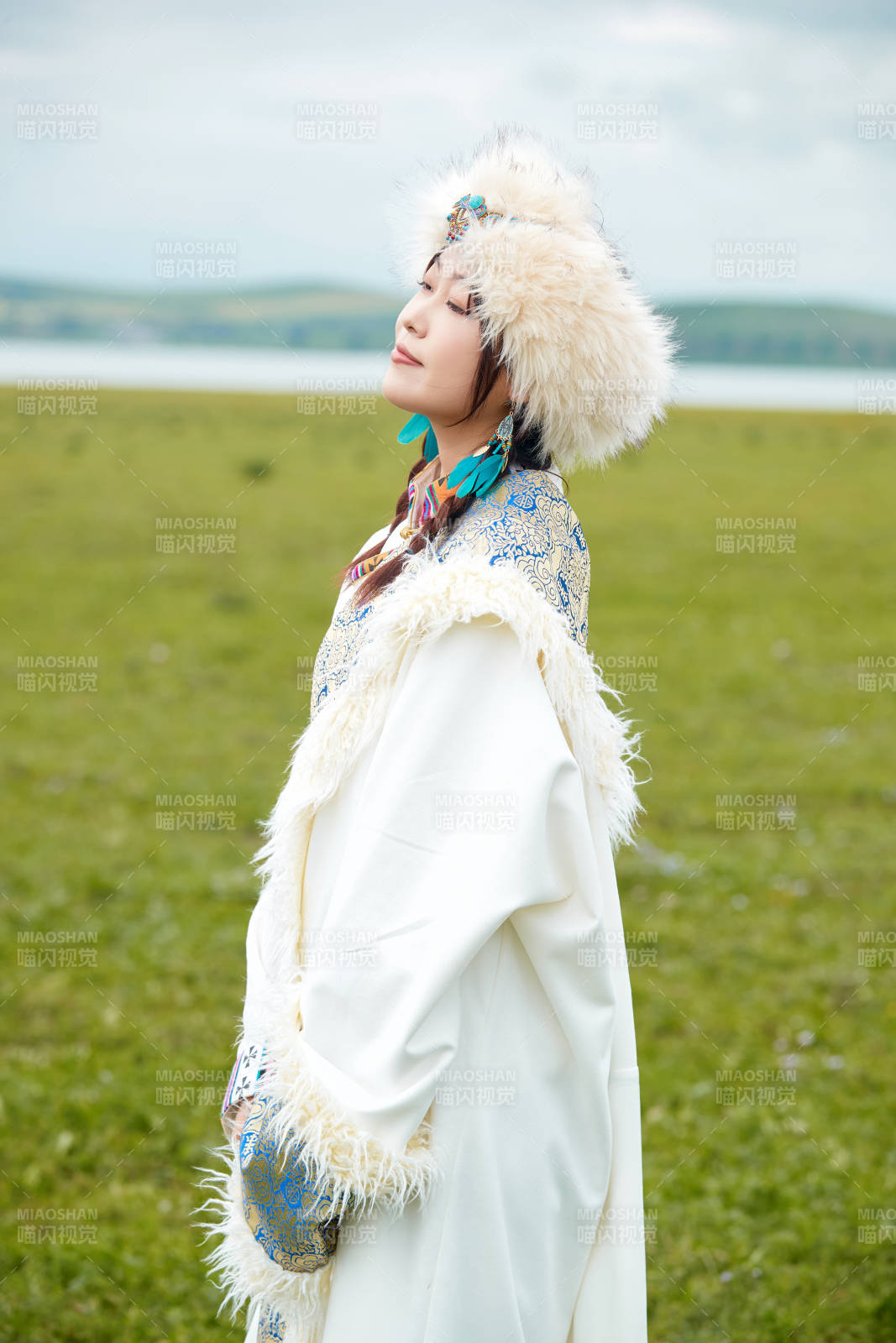 穿白色藏族服饰在草原拍照的少女图片