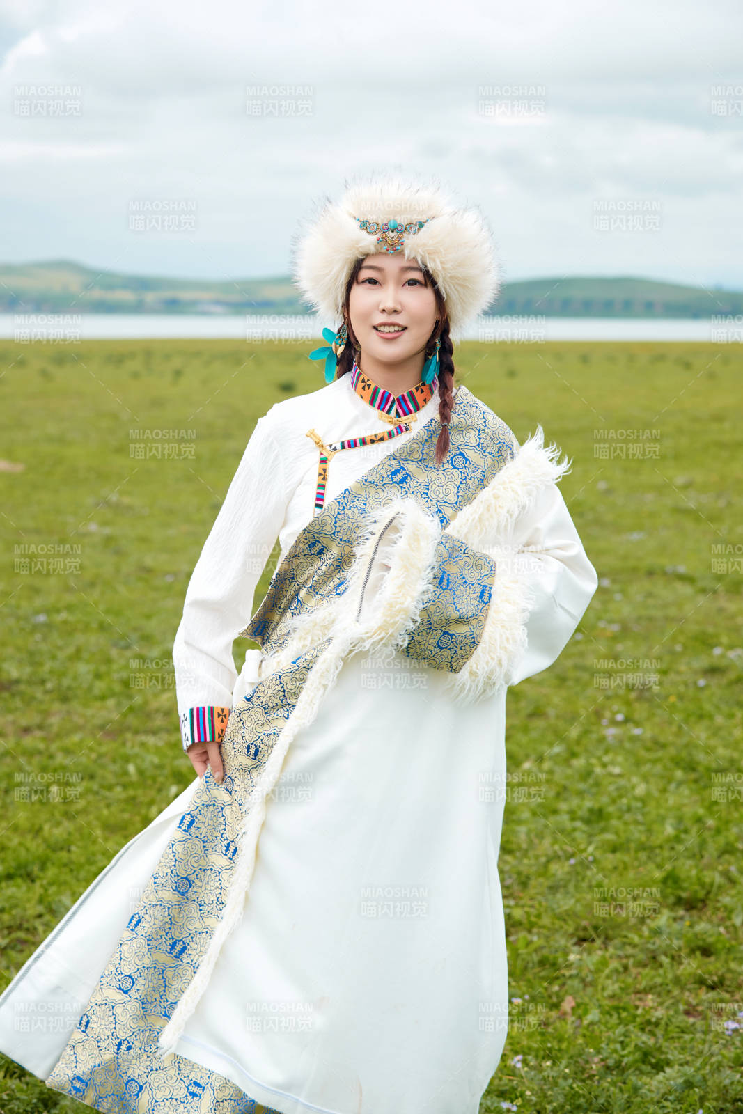 穿白色藏族服饰在草原拍照的少女图片