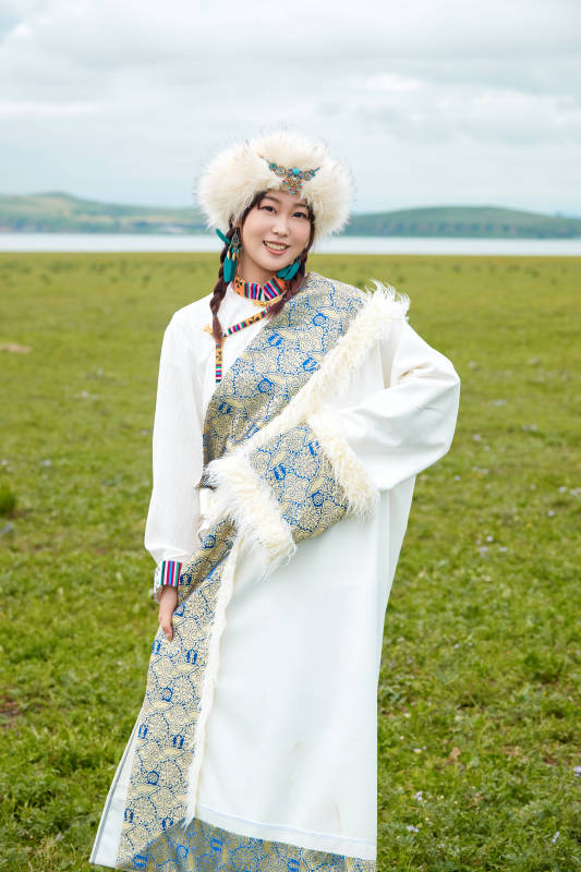 穿白色藏族服饰在草原拍照的少女图片