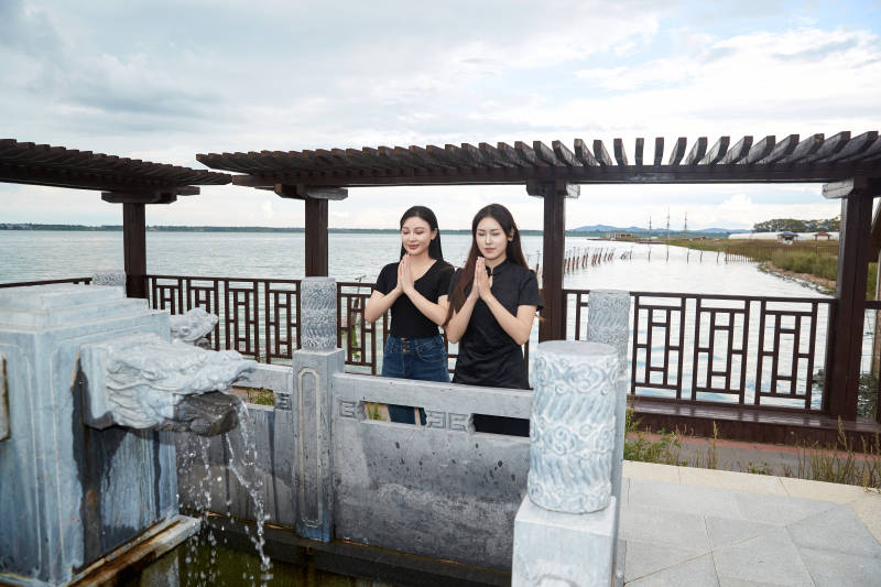 盛夏在景区湖边许愿井祈福的美女图片