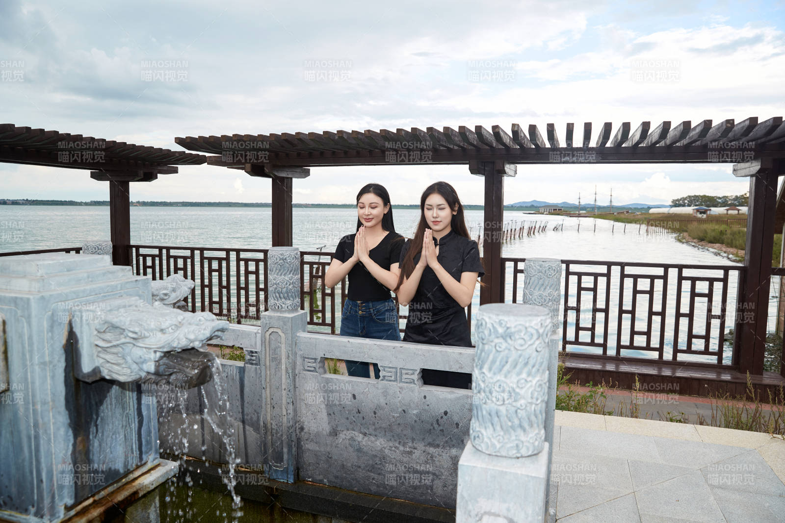 盛夏在景区湖边许愿井祈福的美女图片