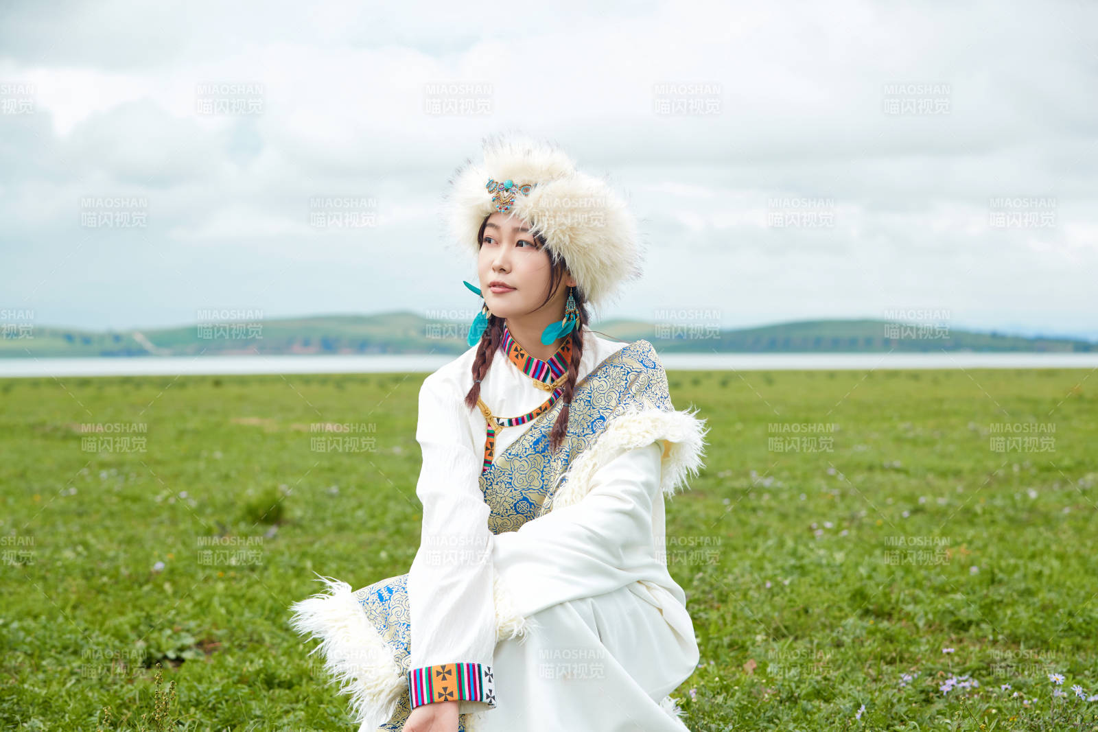 穿白色藏族服饰在草原拍照的少女图片