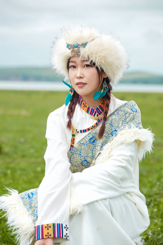 穿白色藏族服饰在草原拍照的少女图片