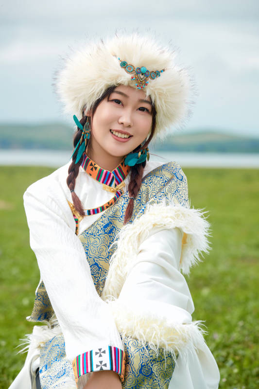 穿白色藏族服饰在草原拍照的少女图片
