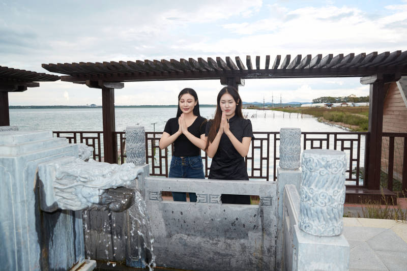 盛夏在景区湖边许愿井祈福的美女图片